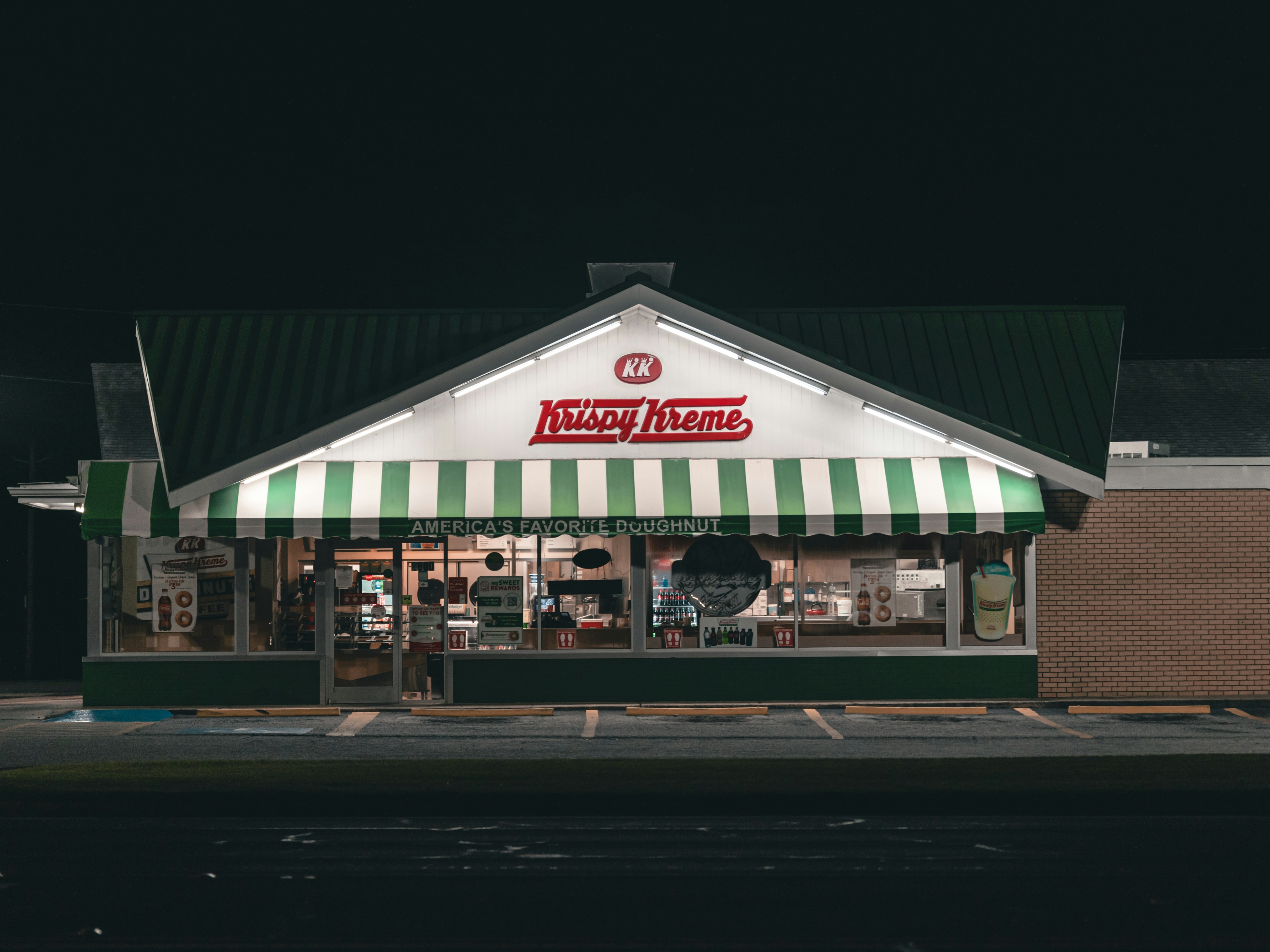 A Krispy Kreme storefront with a Pokémon-themed doughnut display and a customer looking at the limited-time collection