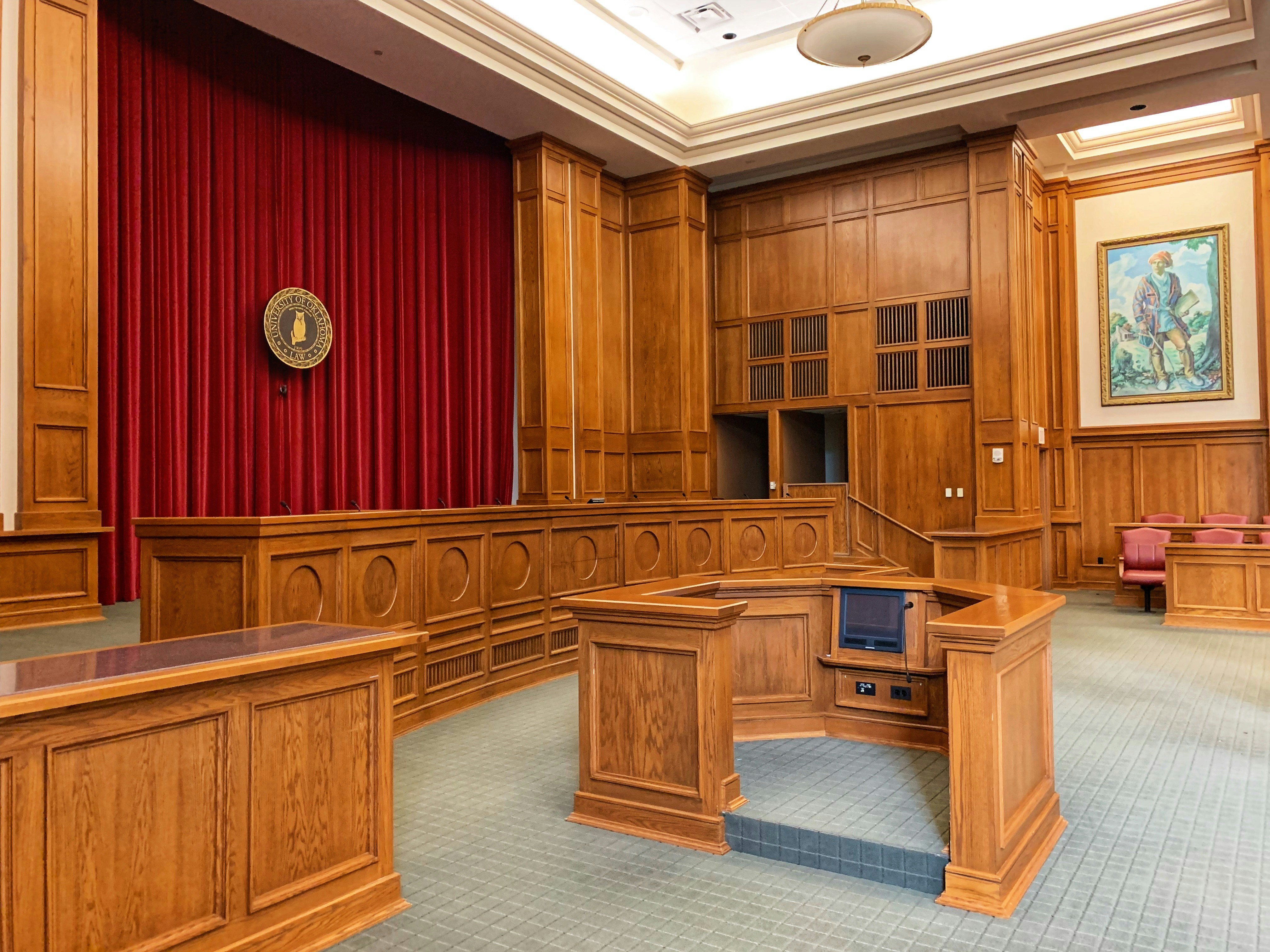 A gavel resting on a desk next to a smartphone displaying a new message notification, representing the intersection of legal proceedings and digital client communication.