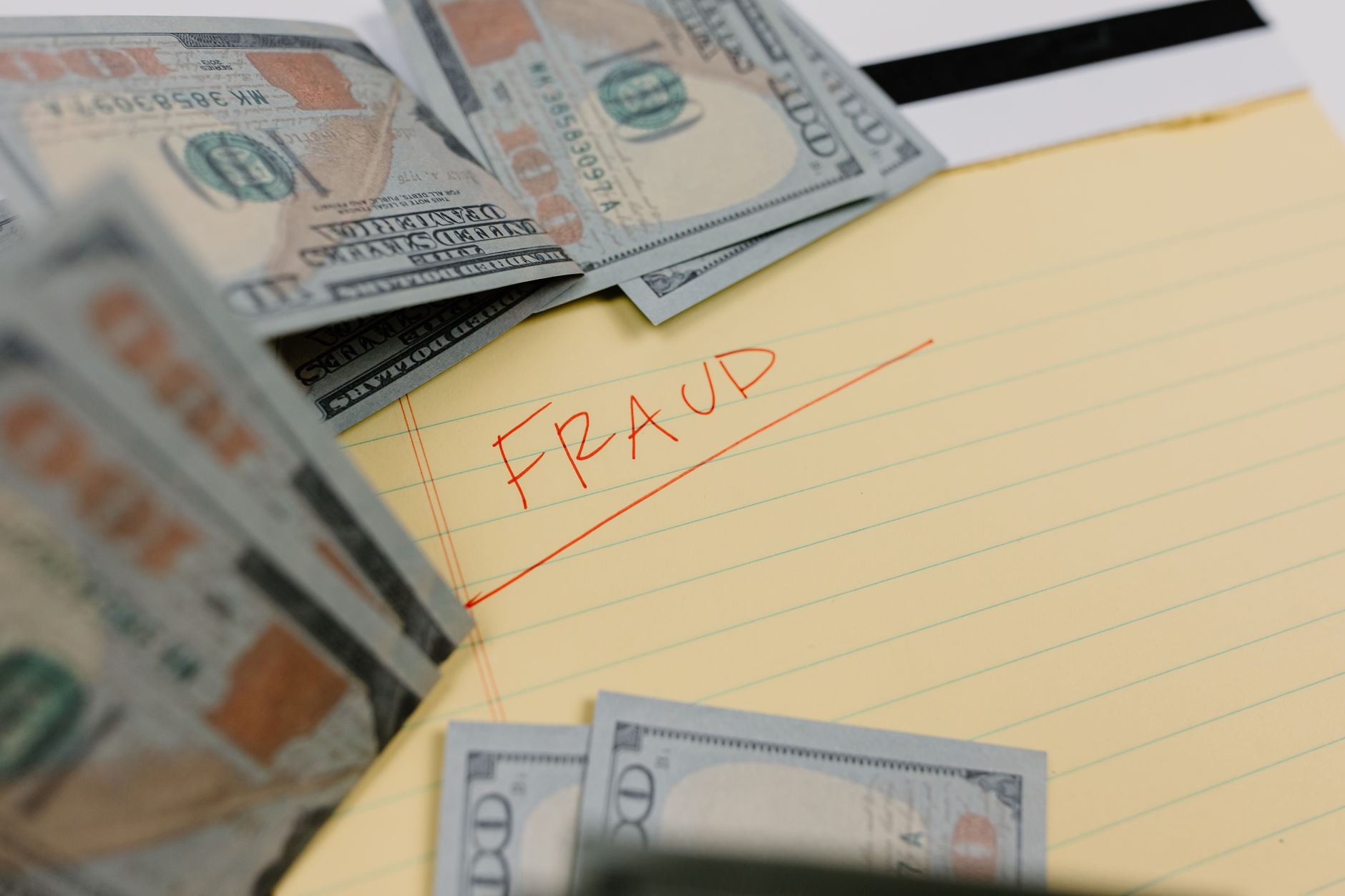 A financial document with a magnifying glass and a red warning symbol, suggesting fraud investigation.