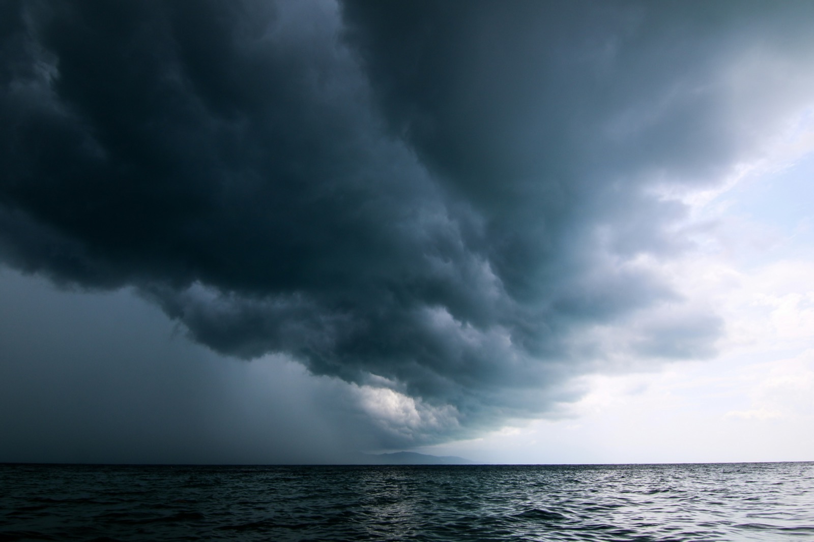 a large storm moving across the sky over a body of water